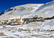 Rongbuk Monastery covered in snow during winter, set against barren Himalayan slopes near Mount Everest in Tibet.
