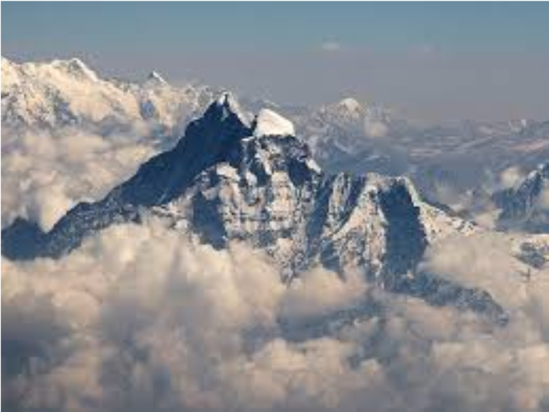 View of Mount Gauri Shankar, with snow-covered peaks emerging above the clouds.