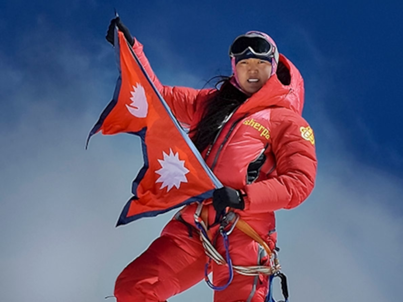 Passang Lhamu Sherpa holding the Nepalese flag atop Mount Everest in 1993, the first Nepali woman to summit the peak.