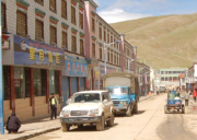Commercial street in Saga with shops, vehicles, and pedestrians along the road