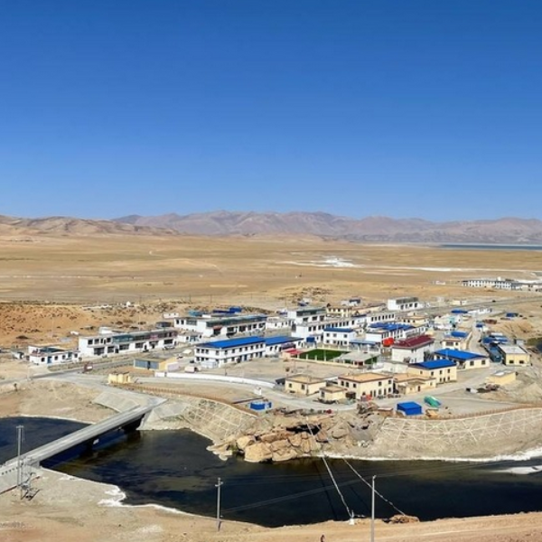 Aerial view of Darchen village with buildings, river, and arid landscape