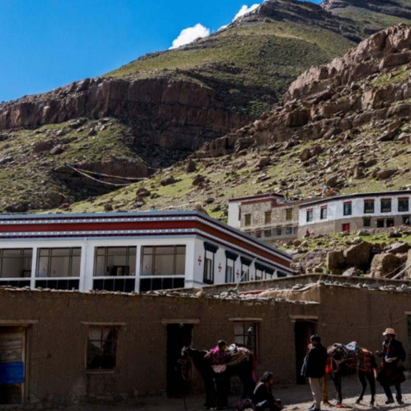 Lodge accommodation at Zuthulpuk with rocky hills and pilgrims near Mount Kailash