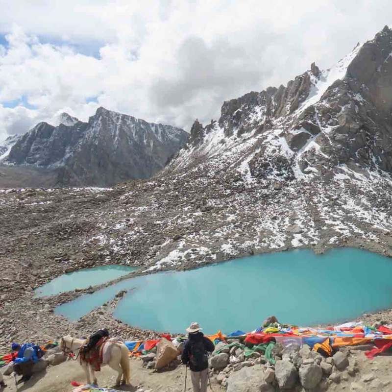 View of Gauri Kunda from Dolma La Pass surrounded by snowy mountains
