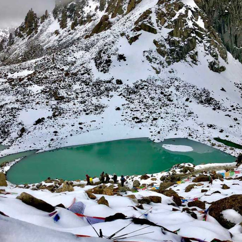 Snow-covered Gauri Kunda lake below Dolma La Pass during winter on the Mount Kailash Kora route.