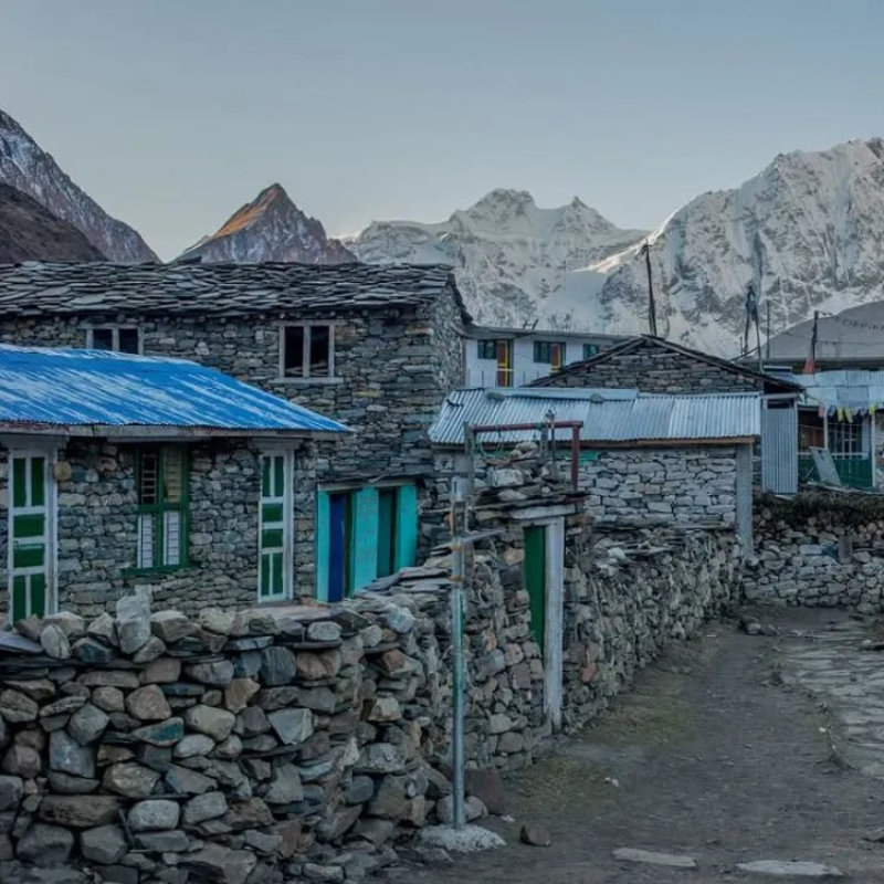 Traditional stone tea houses in Upper Mustang with snowy Himalayan peaks in the background