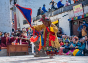 Buddhist monks in traditional robes and ceremonial hats at the Tiji Festival