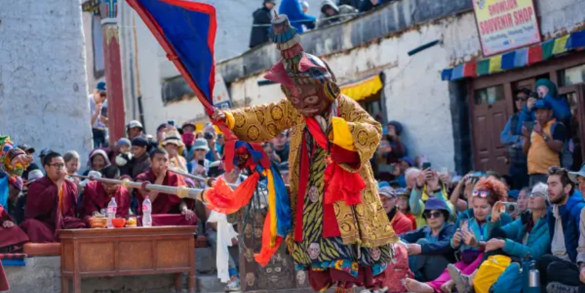 Buddhist monks in traditional robes and ceremonial hats at the Tiji Festival
