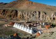 Tirthapuri Gompa and white stupas surrounded by rocky hills near Mount Kailash in Tibet.