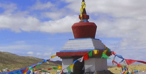 Yama Dwar shrine with colorful prayer flags on the Mount Kailash Kora trail in Tibet.