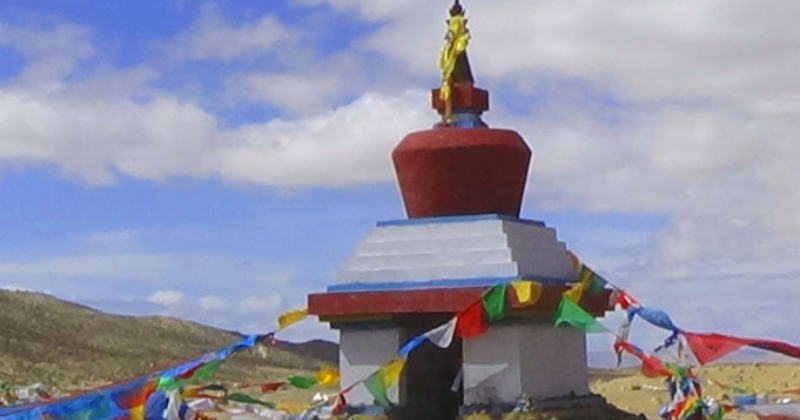 Yama Dwar shrine with colorful prayer flags on the Mount Kailash Kora trail in Tibet.
