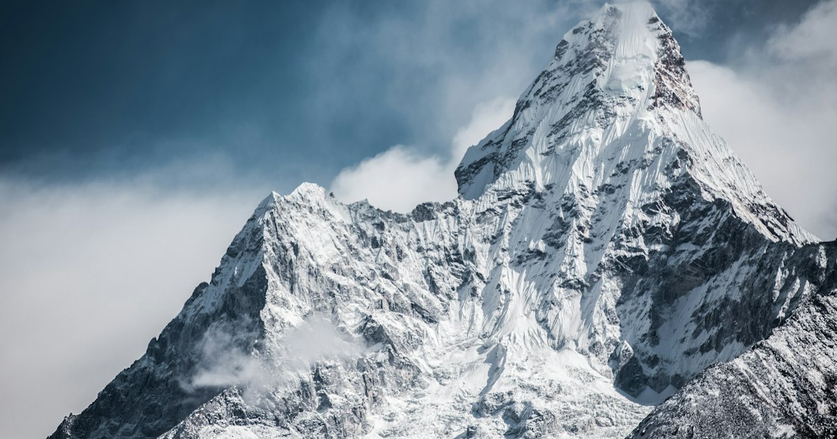 Snow-covered Himalayan mountain range under a dramatic sky